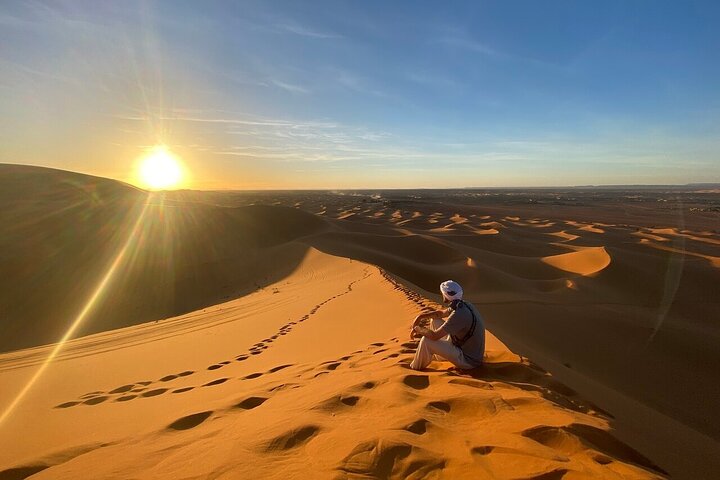 Vast orange sand dunes under a clear blue sky